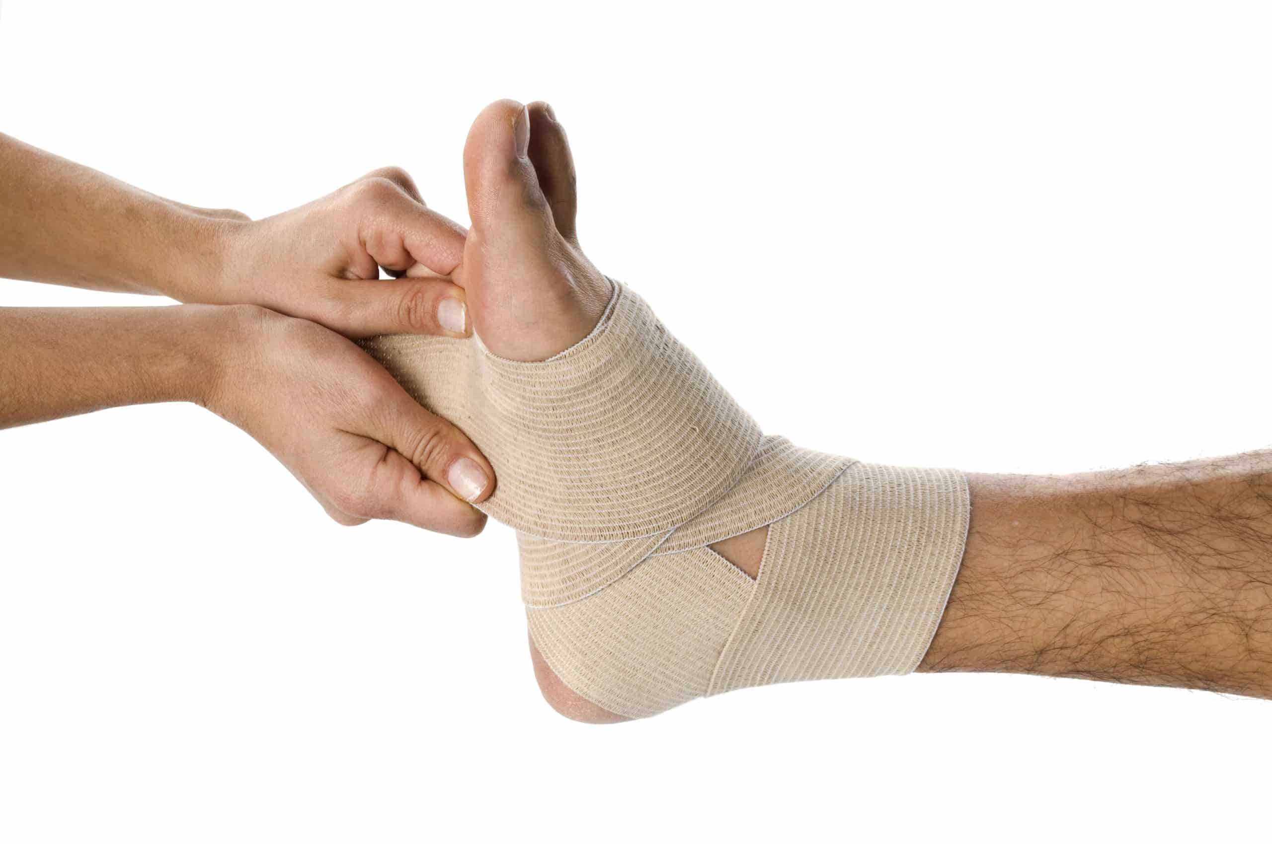 bandage strapping cheville d'un homme appliqué par une femme sur fond blanc