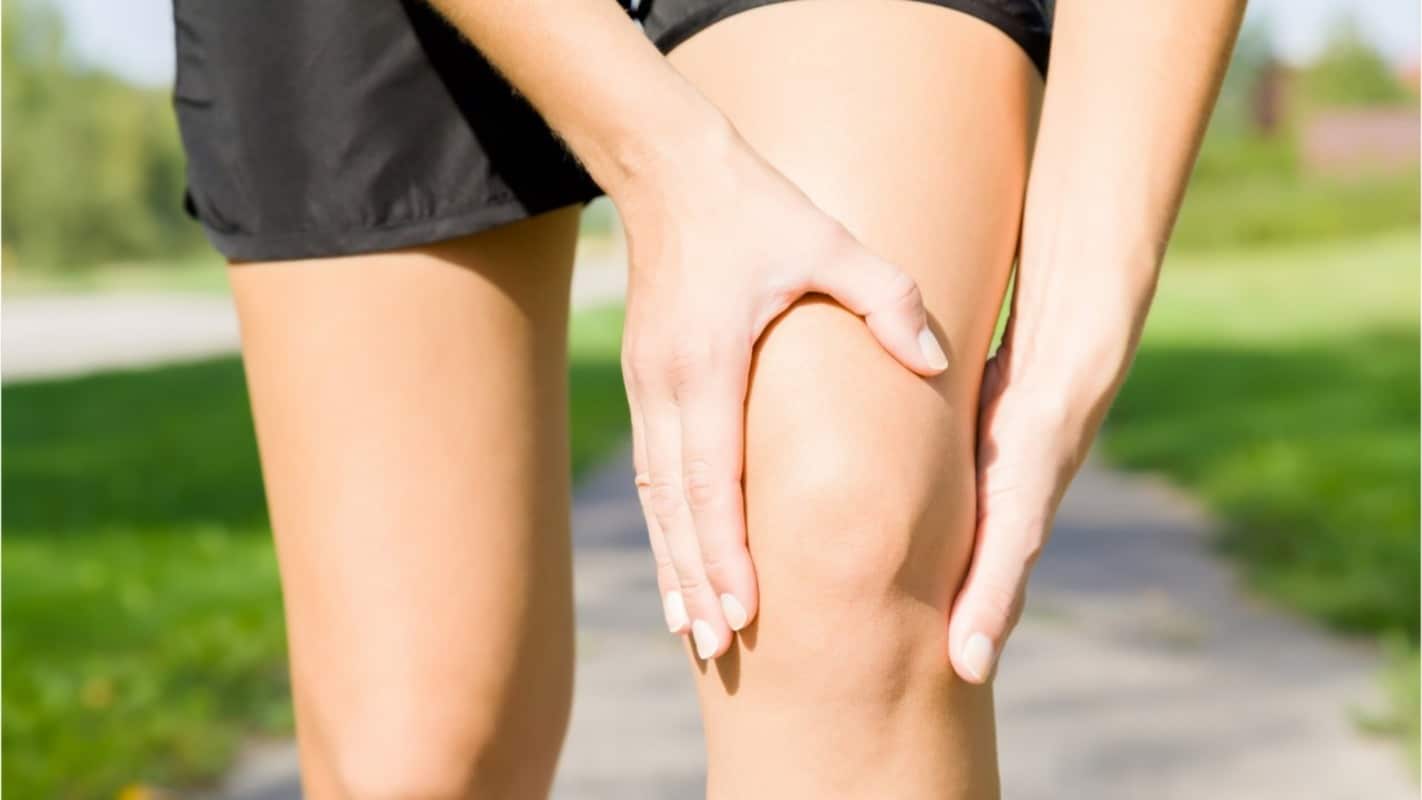 femme se tenant le genou vue de prés en extérieur pendant son sport