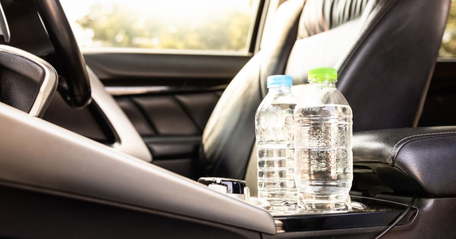 bouteille d'eau en plastique posée dans la voiture à l'avant au soleil