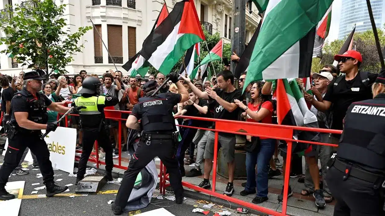 Policier qui repousse des protestants avec des drapeaux palestiniens