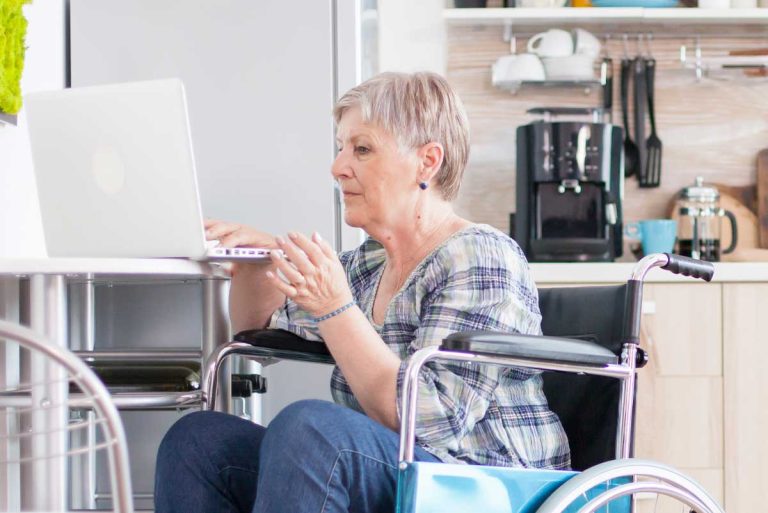 femme en fauteuil roulant sur un ordinateur