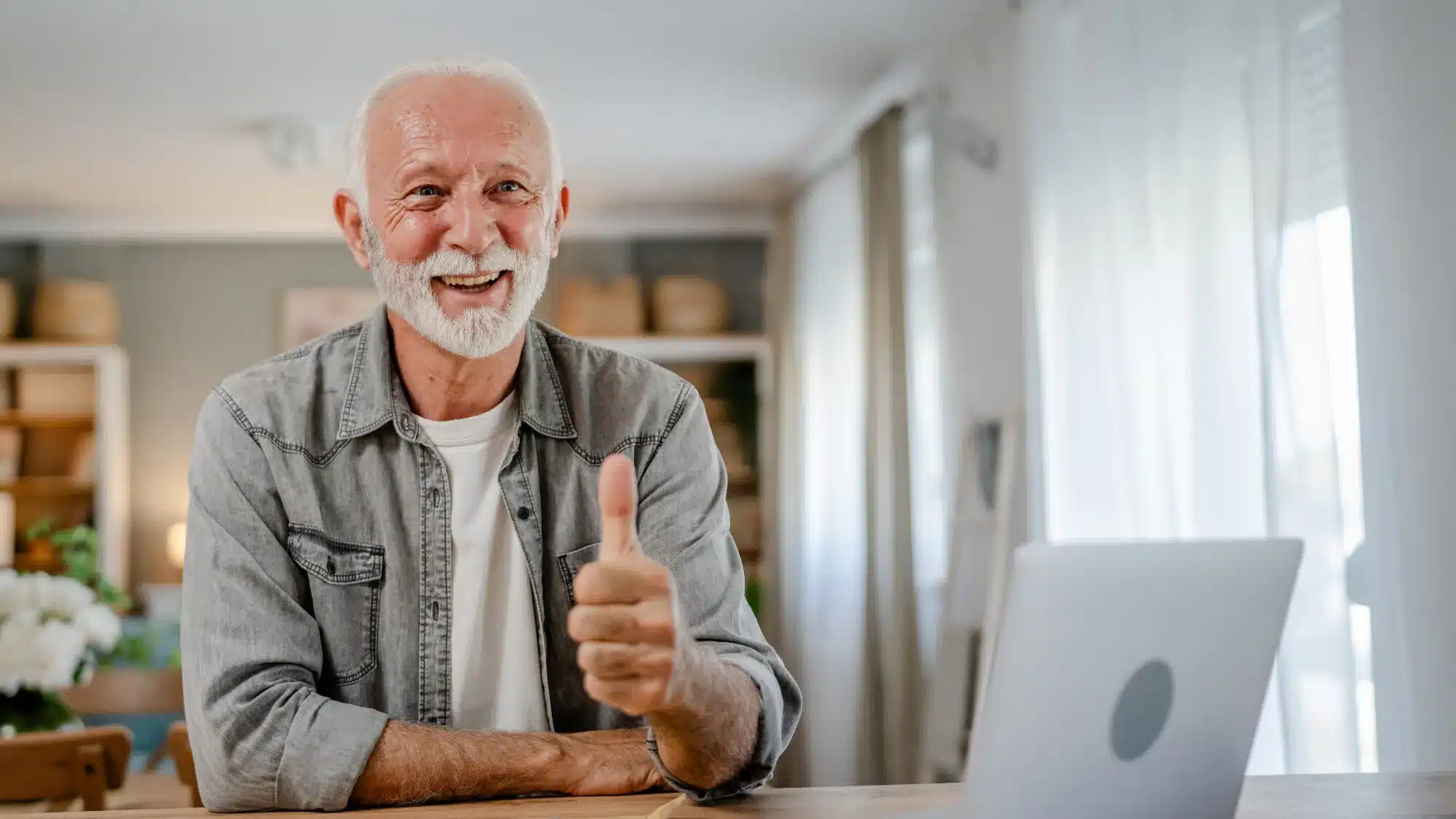 homme agé souriant avec le pousse en l'air