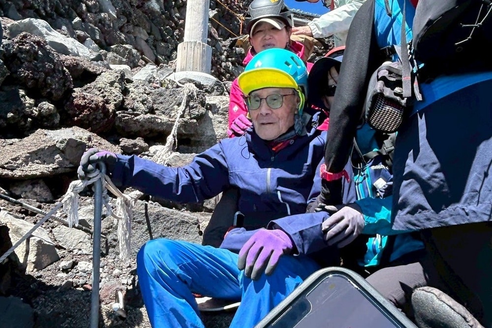 personne agé entrain de gravir une montagne