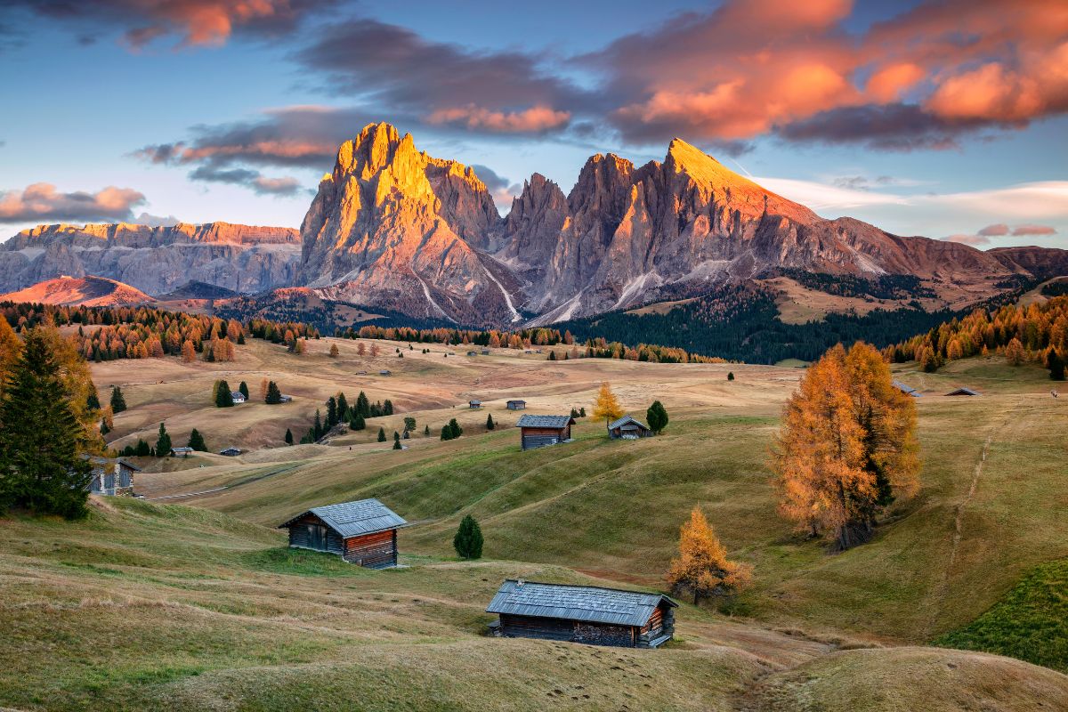 plaine avec les montagnes en fond et un couché de soleil rouge