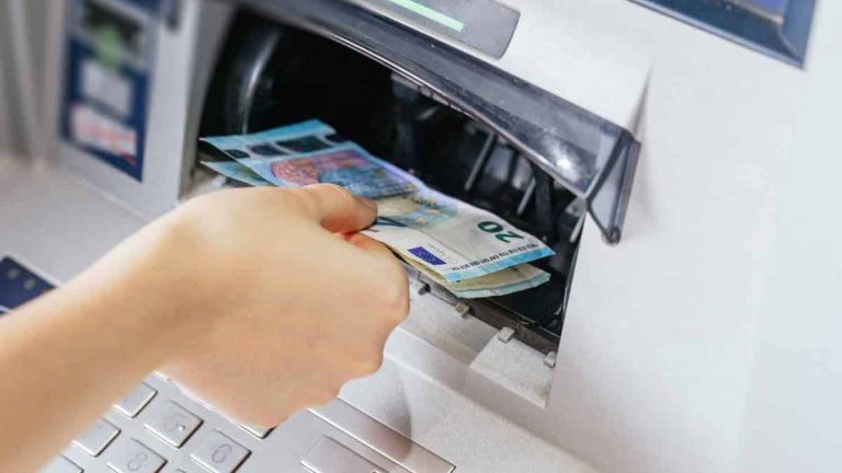 femme qui prend des billets d'un distributeur