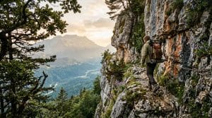 Randonneur équipé sur sentier rocheux montagneux avec vallée