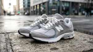 Paire de sneakers New Balance grise et blanche sur trottoir
