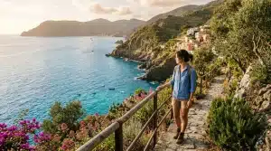 Femme admirant la vue sur village côtier depuis sentier montagneux