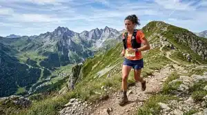 Femme coureur trail dans les Alpes avec vue panoramique