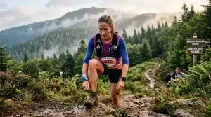 Femme coureur trail avec dossard 349 en montagne boisée