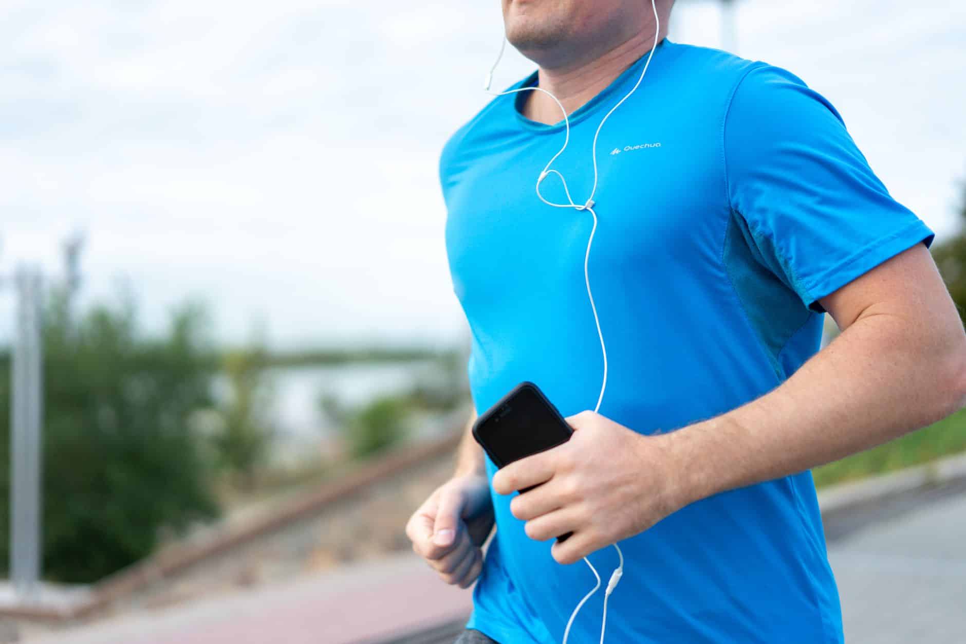 Coureur avec casque conduction osseuse sur sentier côtier La Rochelle